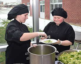 Culinary Arts students Kristina Delos and Courtney Aesch, from Mayfield, prepare delicious Caesar salad for the reception following HFM BOCES Annual Meeting.
