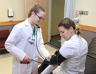 New Visions Health Careers student Lauren Ellis of Mayfield practices her sphygmomanometer skills on instructor Erika Bucenec.