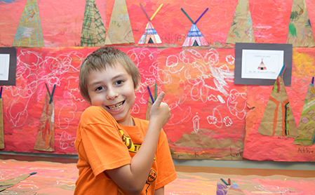 HFM student, Calvin, points out his teepee from a "village" of artwork at the HFM BOCES Academic, Arts & Music Festival.