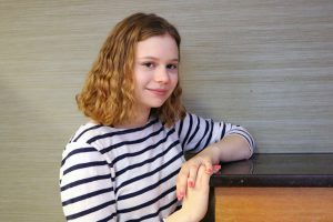 Abby Douglas wearing a striped shirt and leaning on a counter