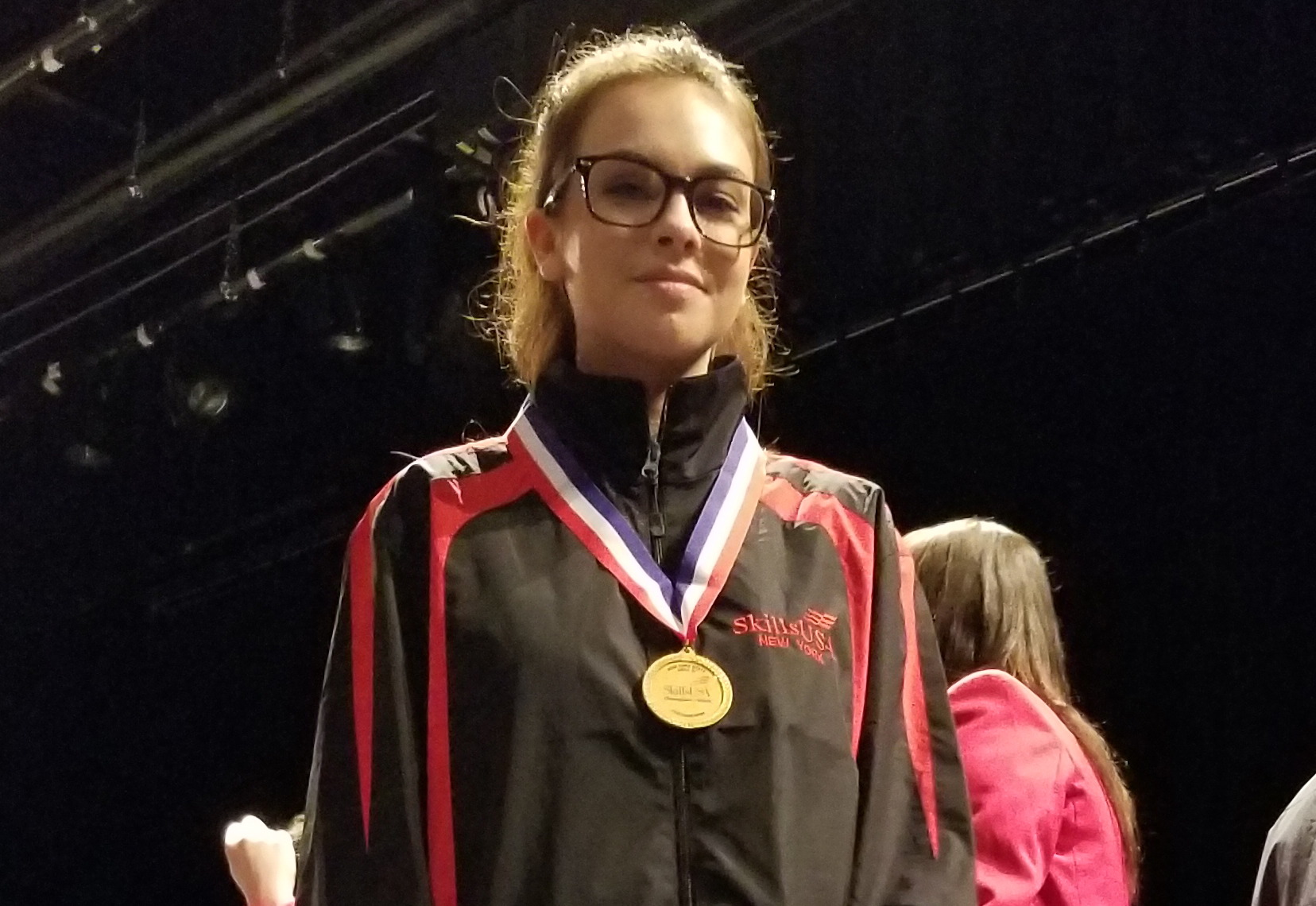 A headshot of Emily wearing a medal