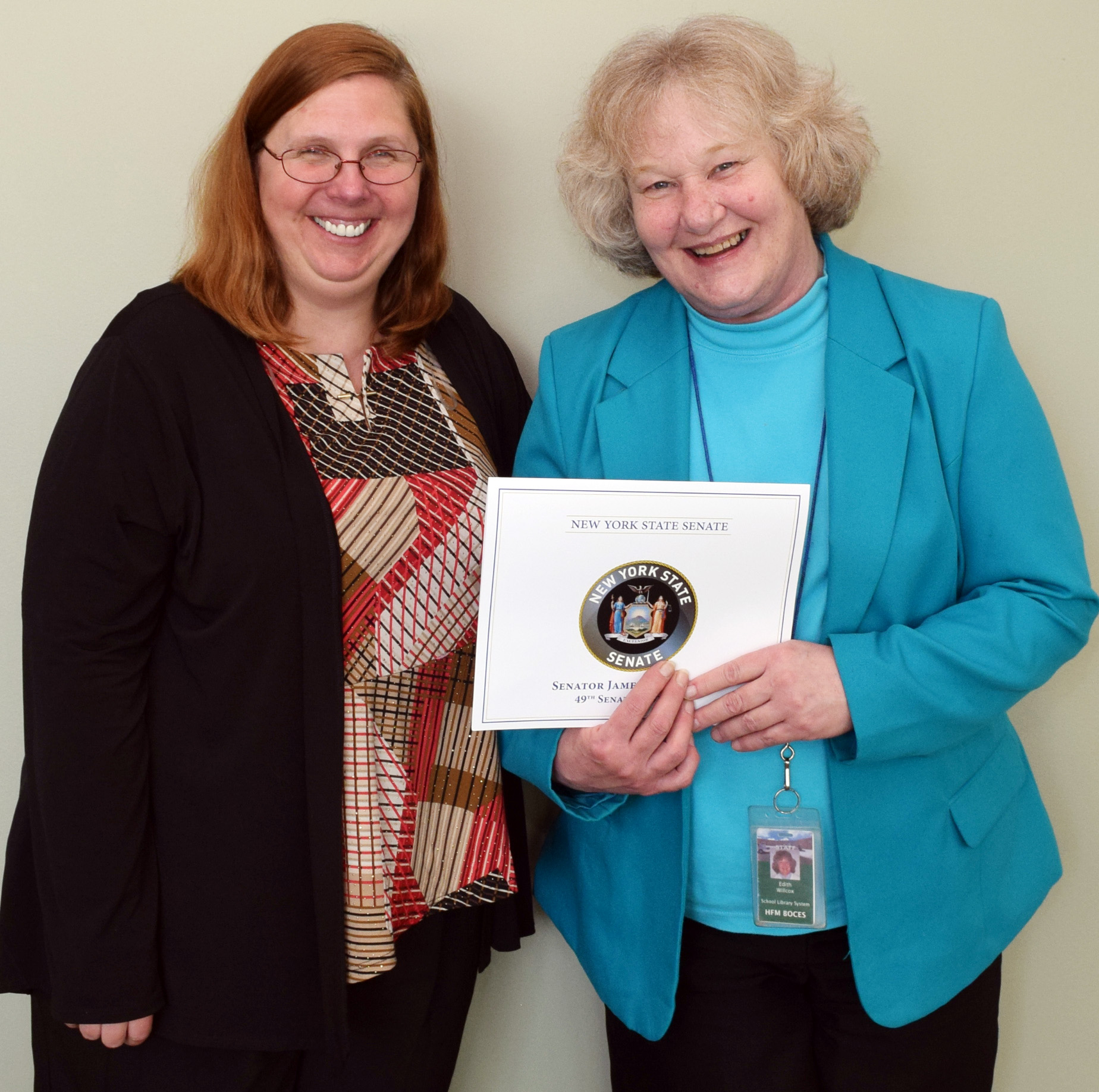 Jennifer Conkling-Donovan and Edie Wilcox stand next to each other. Wilcox holds a citation.