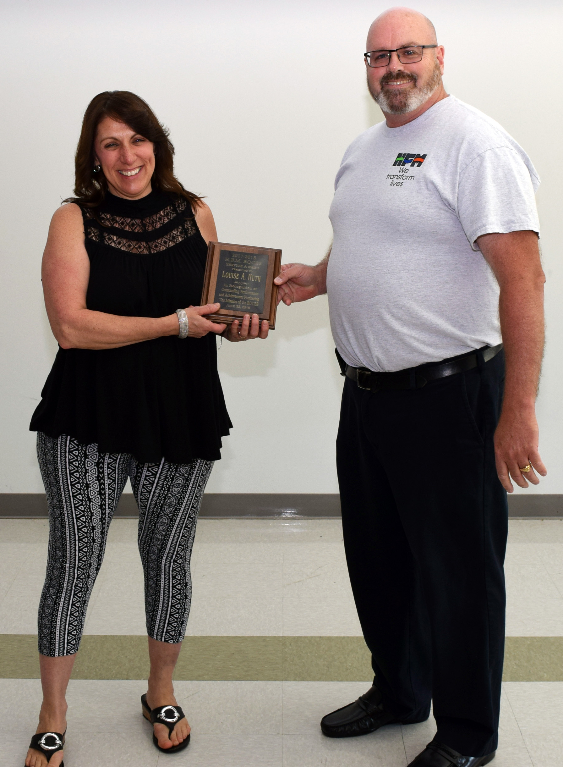 Dr. Michel and Huth hold a plaque smiling for a picture.