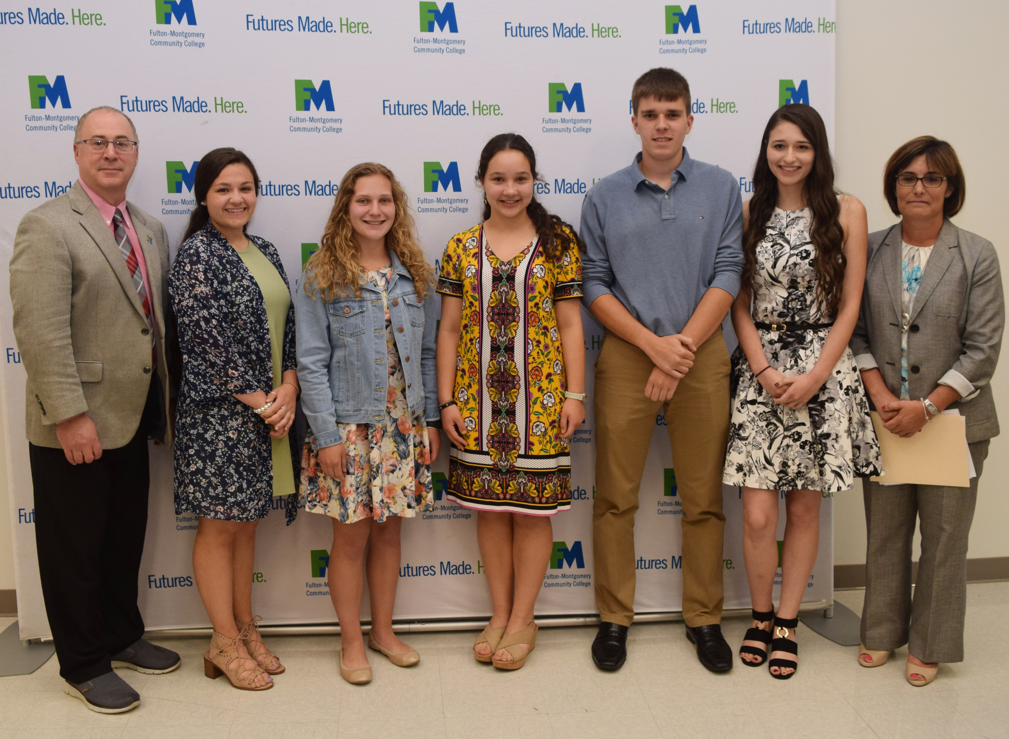 College and school administrators stand in a row posing for a photo. 