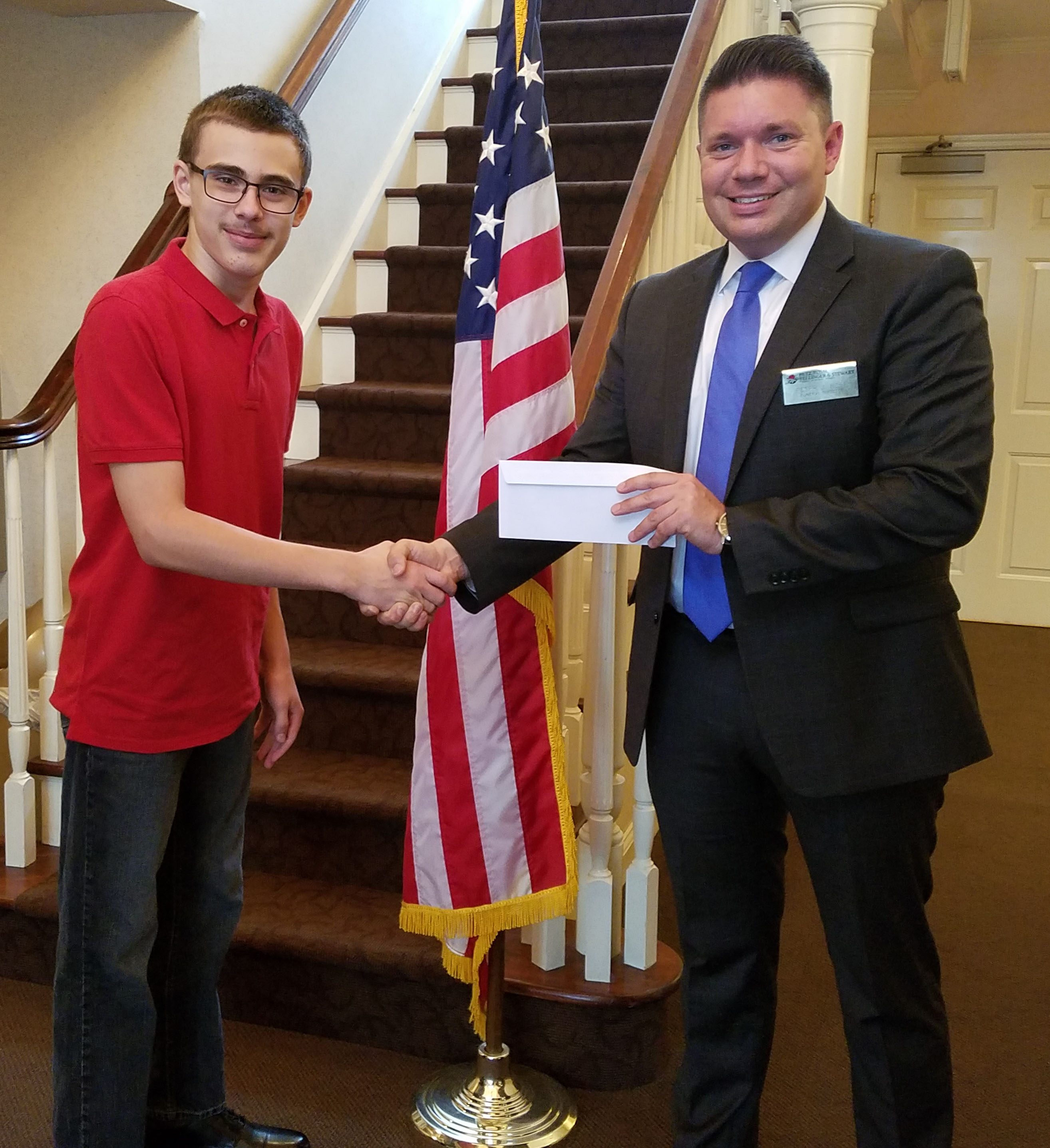 Garrick shakes hands with a funeral home representative who hands him an envelope