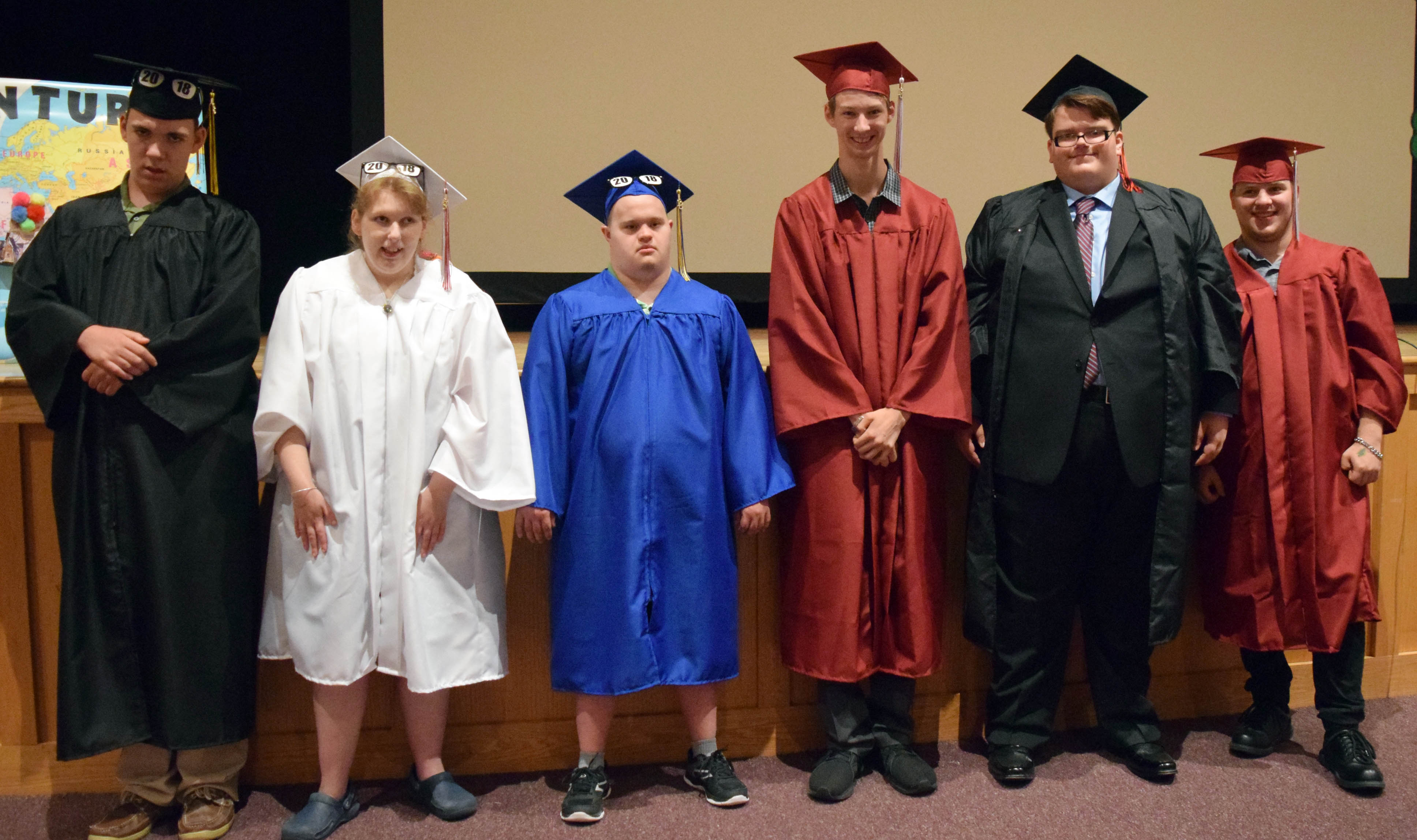 Six graduates stand in a row.