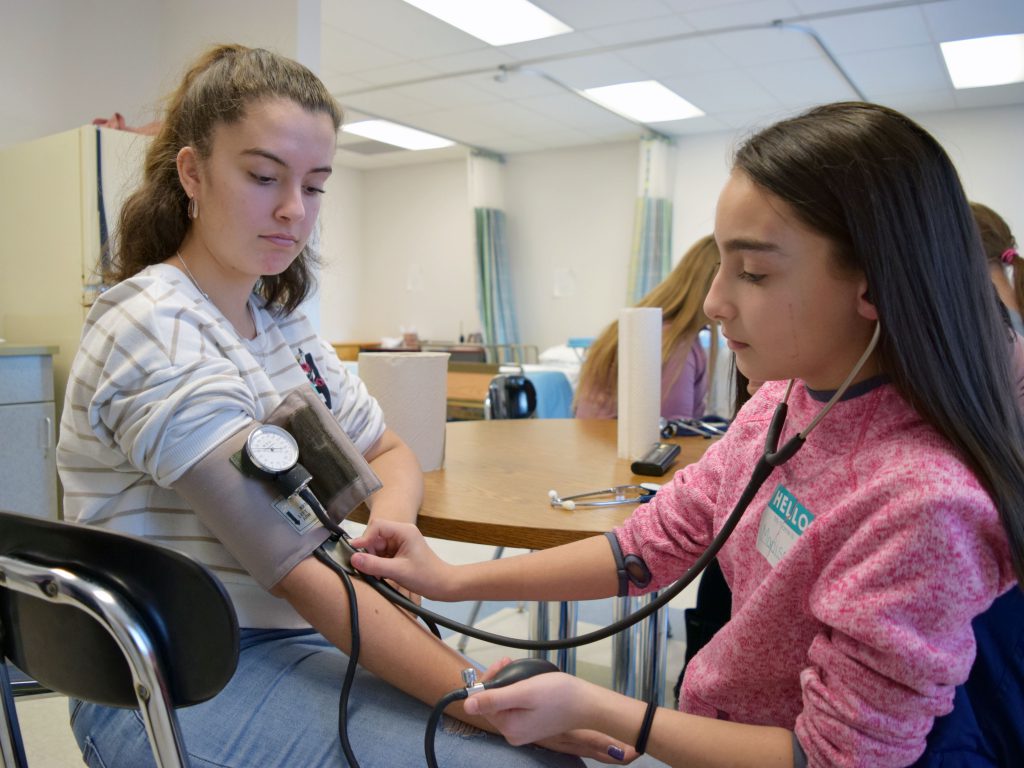 A student checks another student's blood pressure.