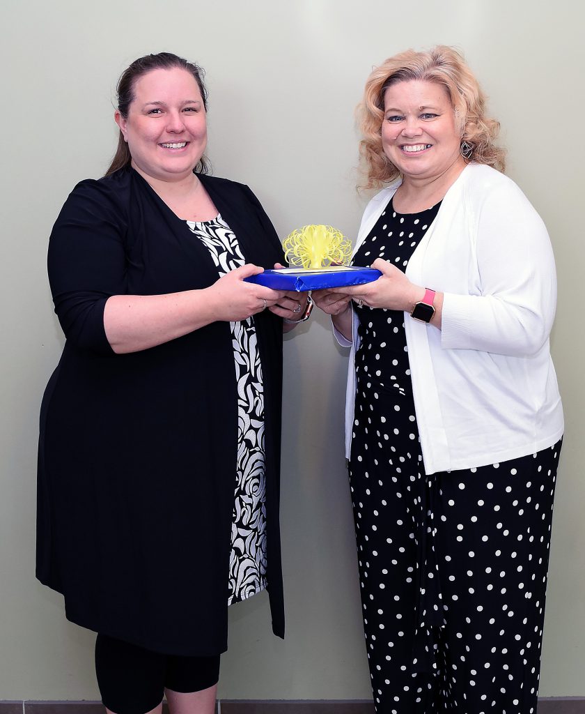 Hanan and Beedon pose for a photo holding a gift that was presented to Hanan.