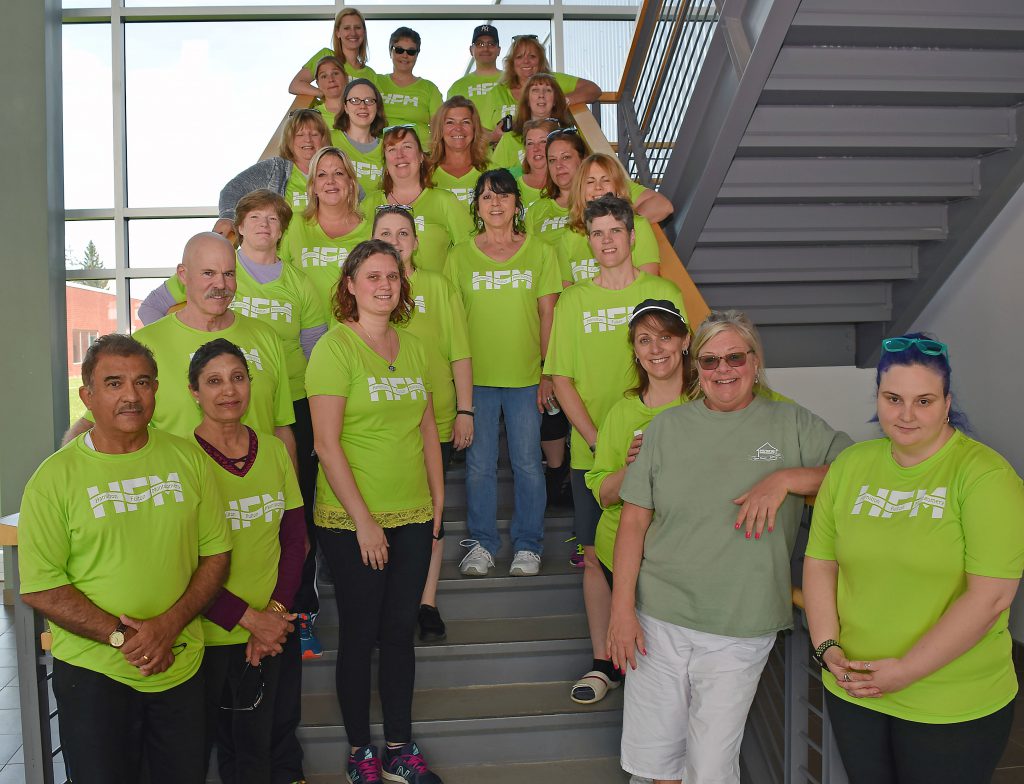 HFM employees pose on a set of stairs for a photo before departing for the race