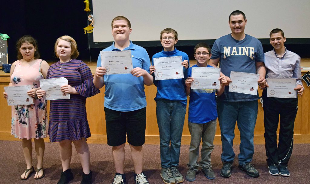 seven students pose for a photo holding their certificates