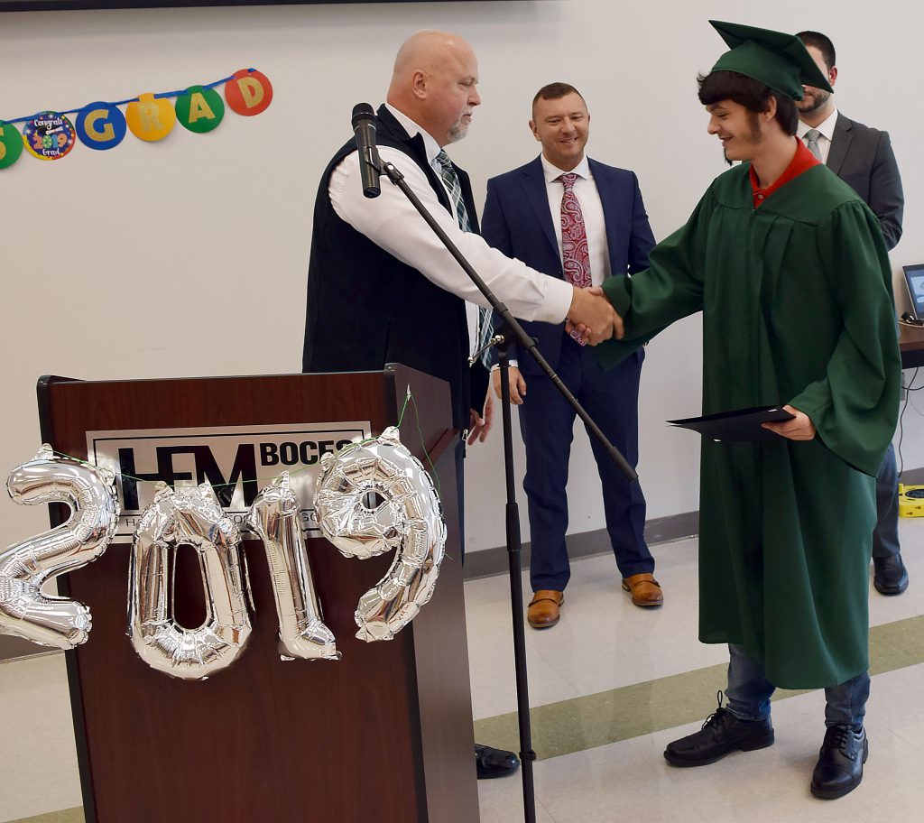 A students shakes the principal's hands after receiving an award