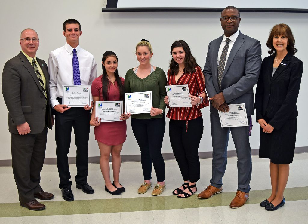 Students hold their certificates and stand with college, BOCES and school administrators to pose for a photo