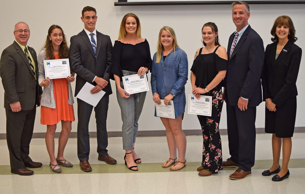 Students hold their certificates and stand with college, BOCES and school administrators to pose for a photo