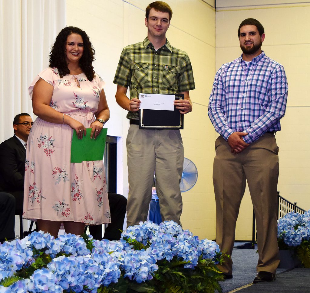 A students and two of Ben Conte's children pose for a photo from the stage