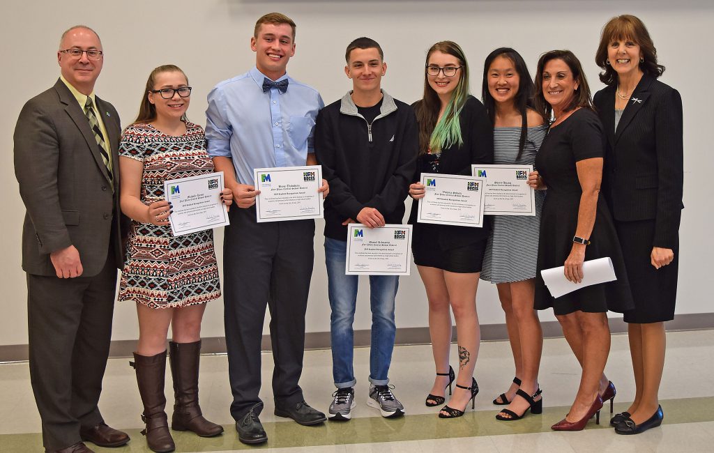 Students hold their certificates and stand with college, BOCES and school administrators to pose for a photo