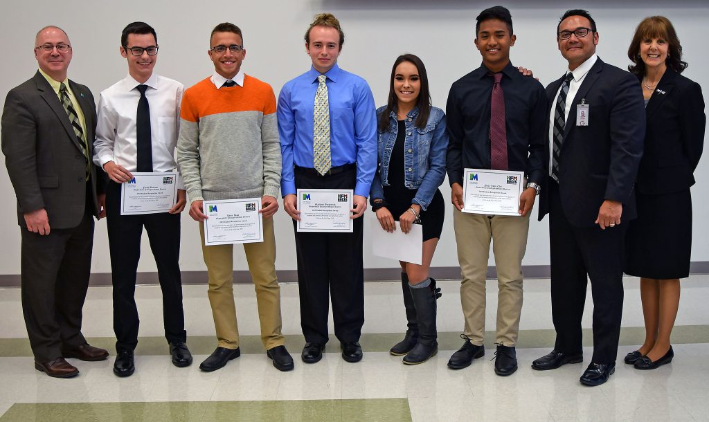 Students hold their certificates and stand with college, BOCES and school administrators to pose for a photo