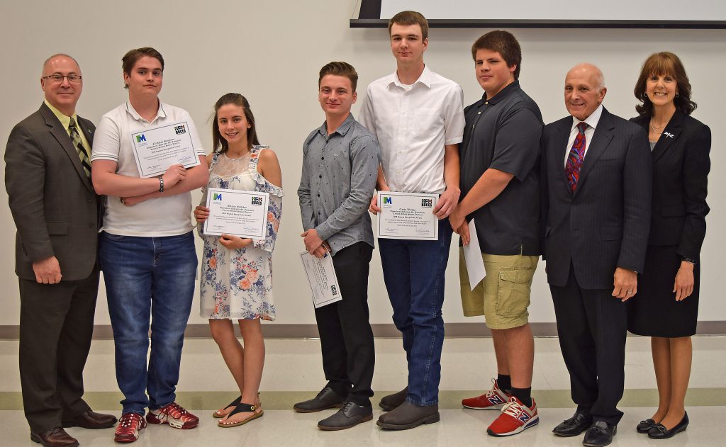 Students hold their certificates and stand with college, BOCES and school administrators to pose for a photo