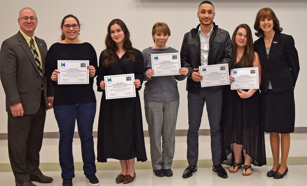 Students hold their certificates and stand with college, BOCES and school administrators to pose for a photo