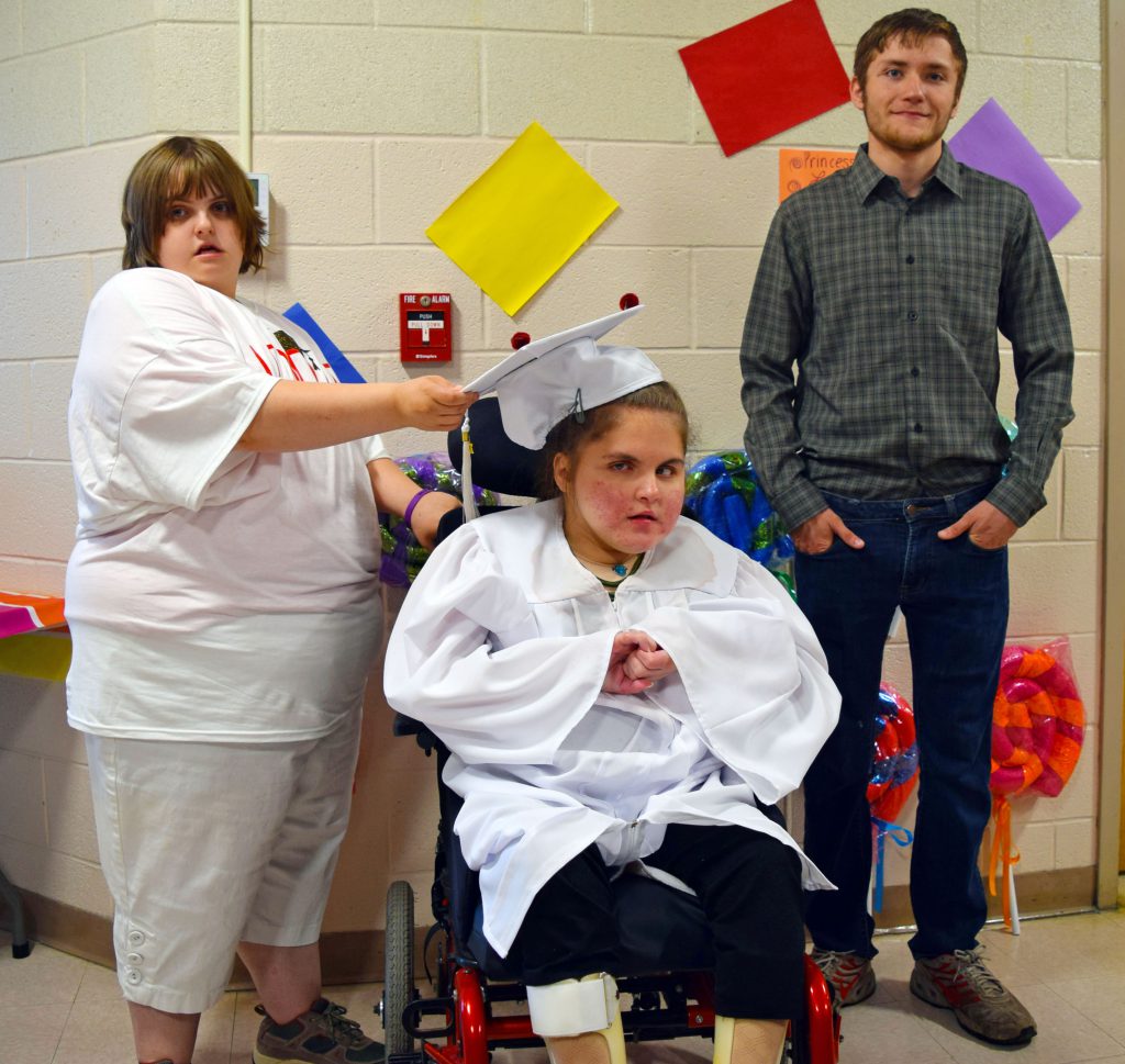 three students pose for a photo after graduation