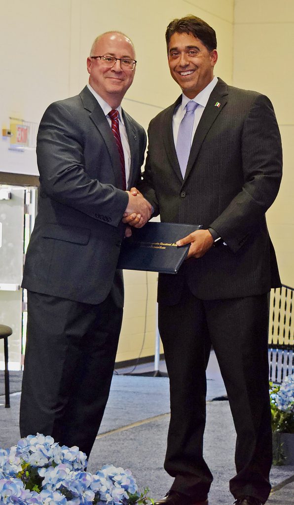 Swanger and DeTraglia shake hands as DeTraglia hands Swanger a certificate