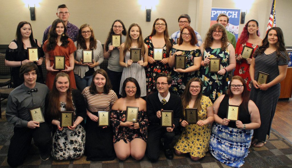 Group of students posing holding plaques