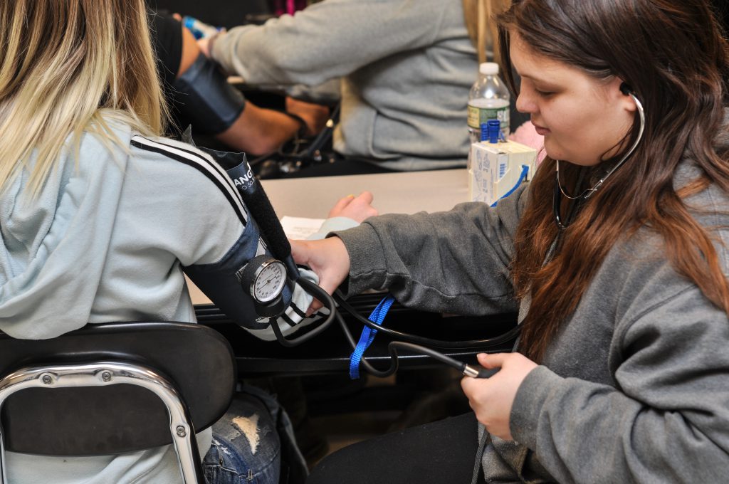 A student checks another student's blood pressure