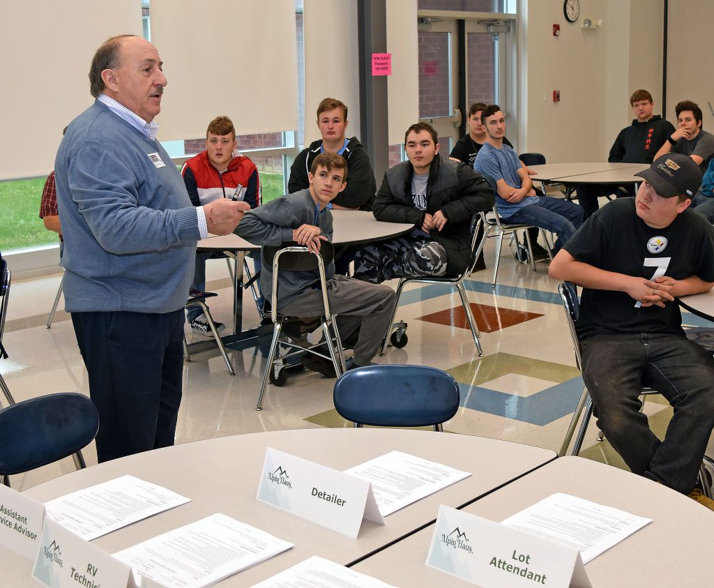 A man speaks with students.