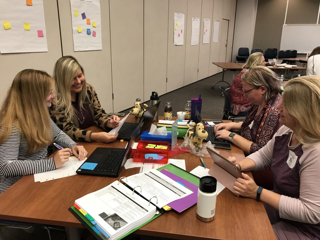 Four librarians sitting at a table working together