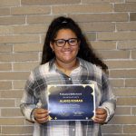 Alanis Roman standing holding her award