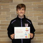 Bryen Belknap standing holding his award