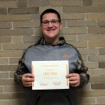 Luke Paige standing holding his award