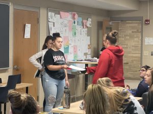 Student handing an award to another student.