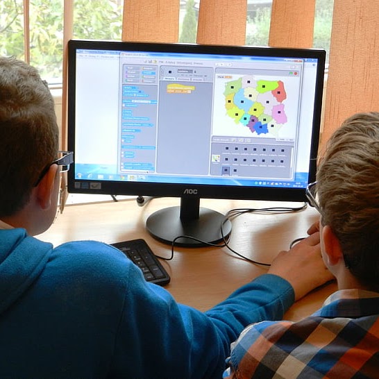 two students sit at a computer monitor
