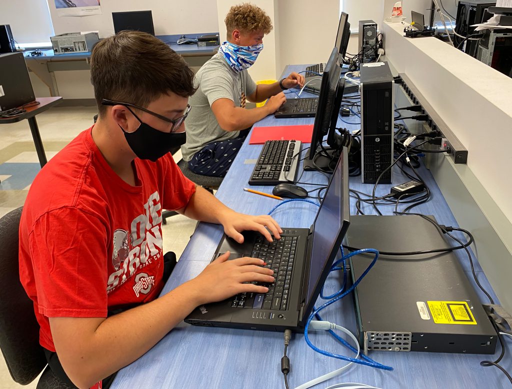 Two students work at laptop computers