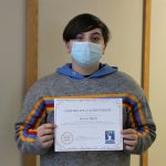 Male student holding certificate