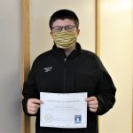 Male student holding certificate