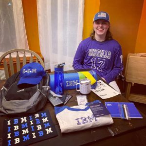 Student sitting at table with IBM items