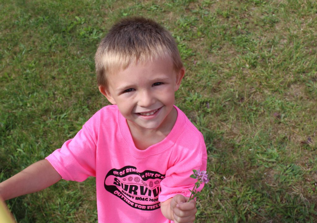 A student outside holds a flower