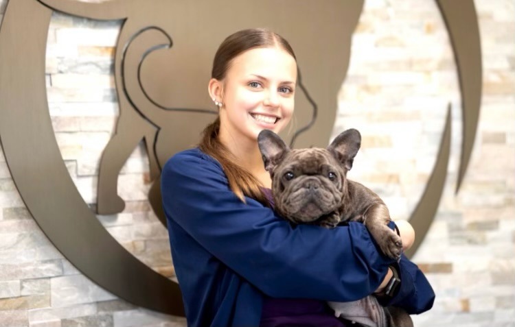 Azia Aldi holds a French bulldog 