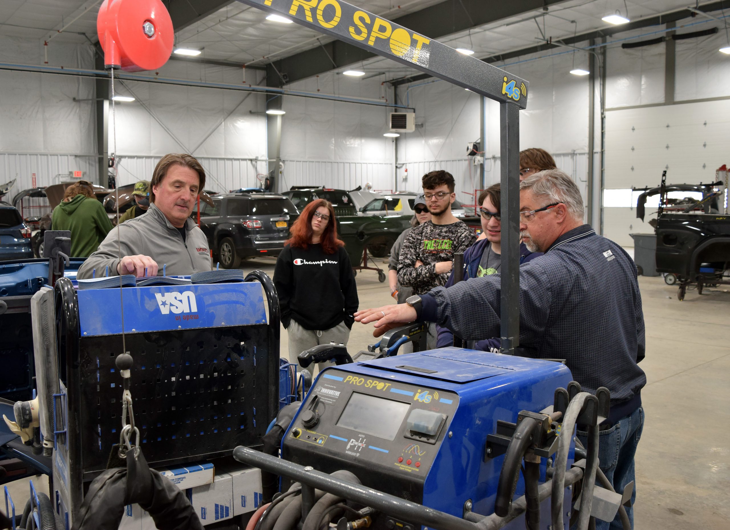 Derek Brown and John Ackermann show students equipment in the new Brown's Ford collision center.