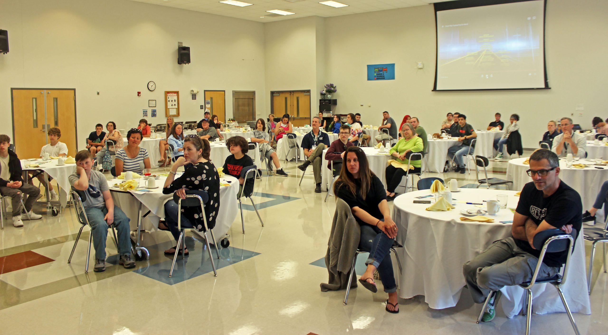 groups of people sit at table in a conference center