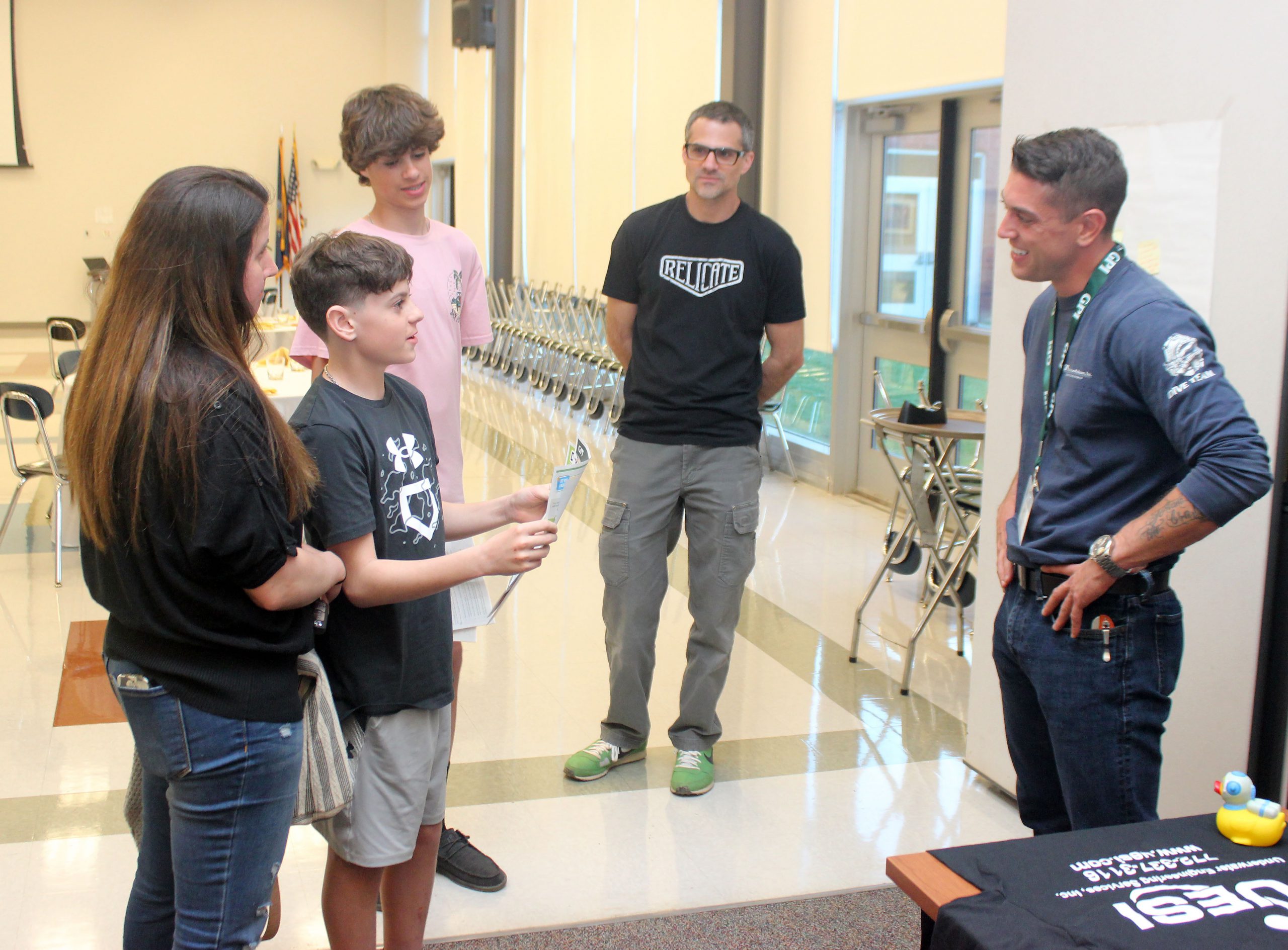 Maxwell Faulkner, an underwater diver for GPI speaks in a small group with two students and family members