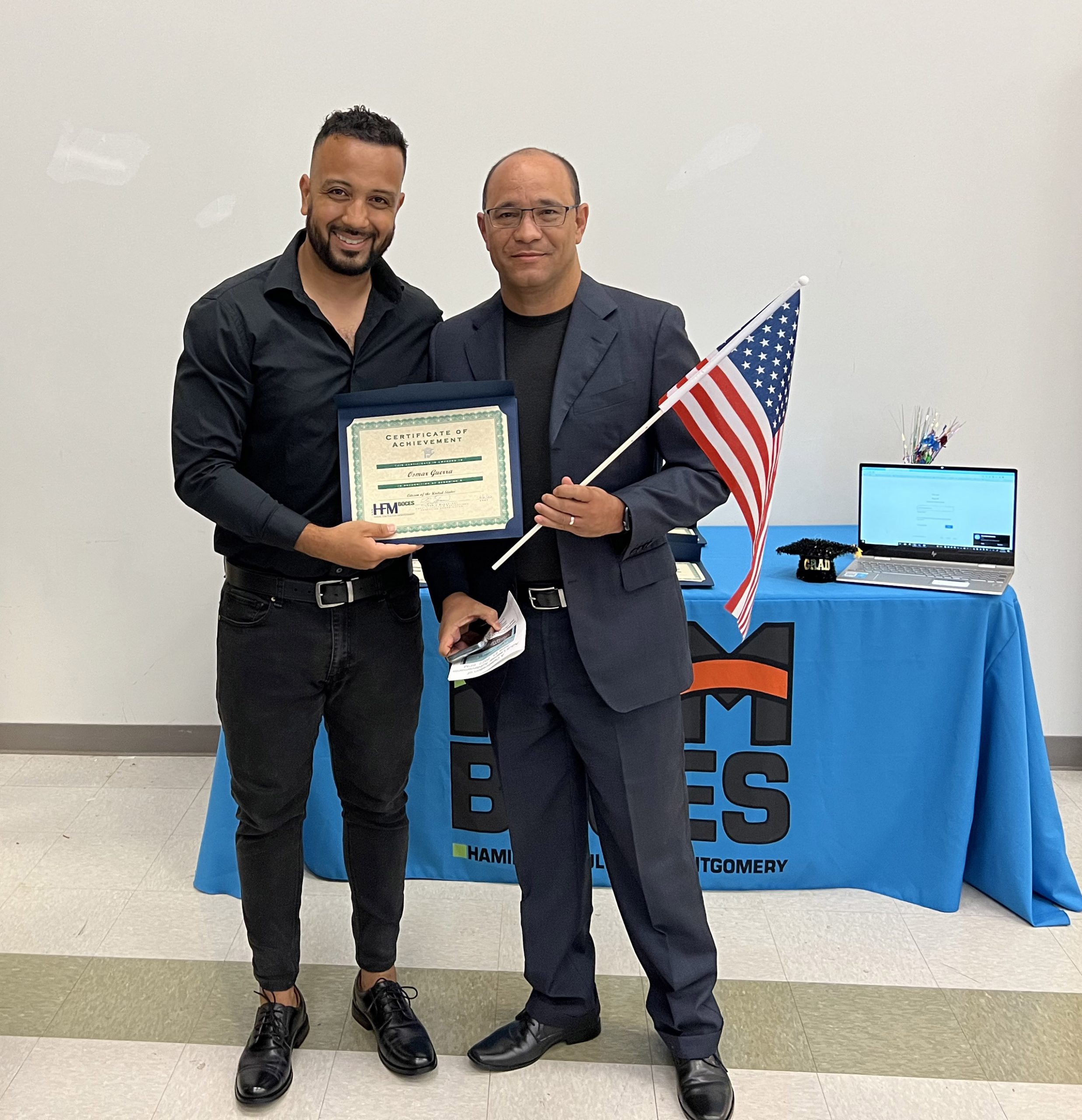 Adult Educator Geovanny Santamaria congratulates an adult student from Cuba who recently attained U.S. citizenship.