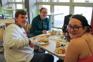 Three students enjoy their Thanksgiving meals together