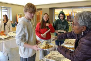 PTECH principal Celeste Keane serves food to student