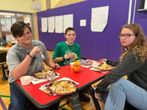 Group of three PTECH students enjoying a meal together