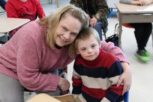 An adult poses with a student from Meco Academy