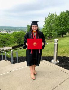 Molly Monge is a 2018 HFM BOCES New Visions Health graduate and CTE alum. She is pictured wearing her college cap and gown while posing with her diploma.