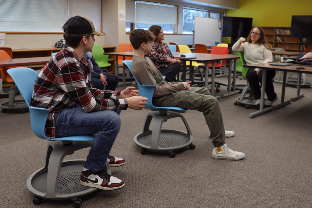 Students sit in a classroom and listen to a presenter talk about writing and developing a resume.