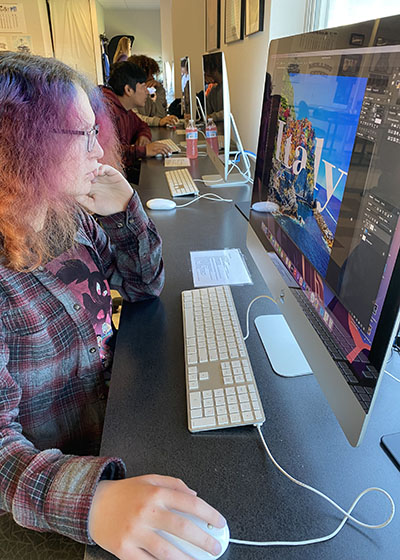 A student works on graphic design project on a computer.